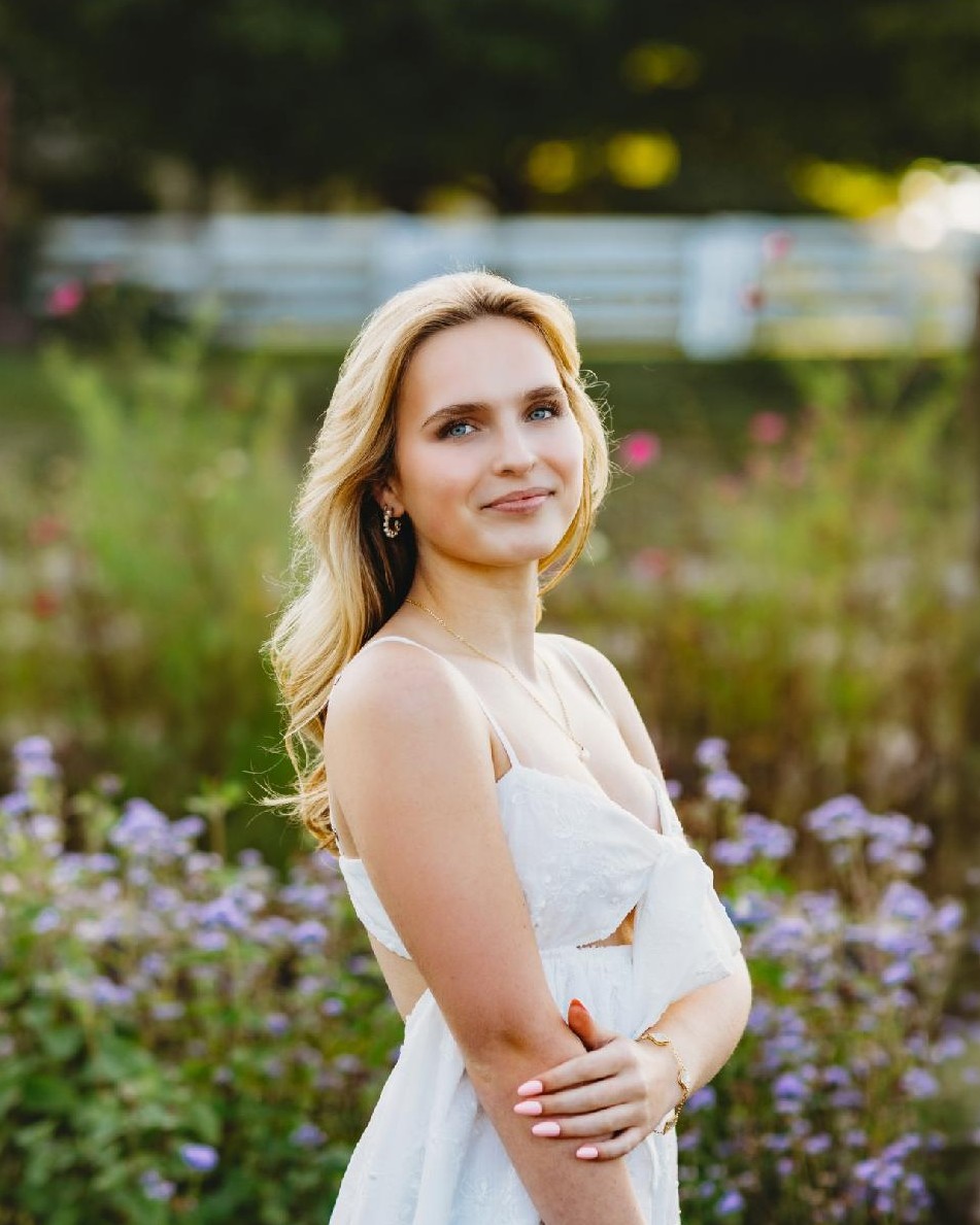 Madelyn Wright in a white dress in a purple-and-pink flower garden